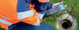 Profissional realizando caça vazamentos com geofone em tubulações, identificando pontos de vazamento de agua de forma precisa.